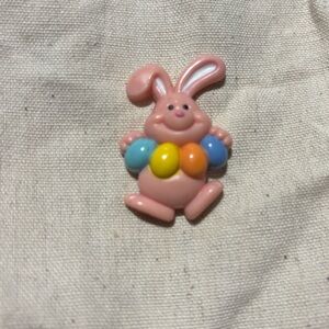 Russ Vintage pink plastic Easter bunny rabbit pin or brooch holding colored eggs